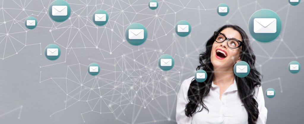 Emails with happy young businesswoman on a gray background